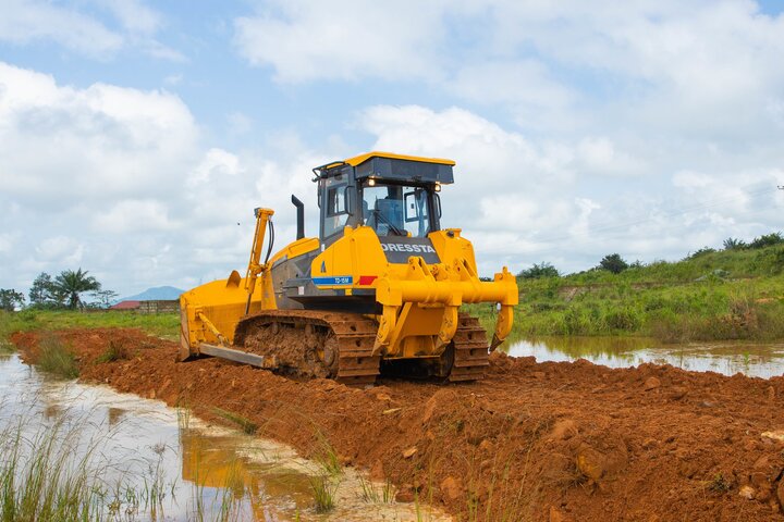 Dressta bulldozer performing heavy-duty earthmoving and land preparation in a challenging, rugged environment