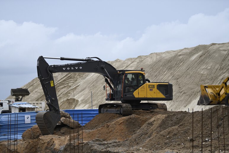 Pelle moyenne Volvo en action sur un chantier de construction routière exigeant, offrant précision et efficacité pour les projets d'infrastructure