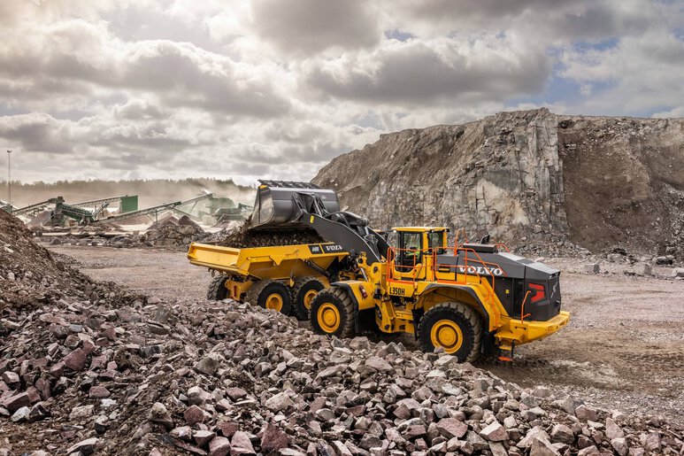 L’imposante chargeuse Volvo L350 en pleine opération de chargement au front de taille dans des conditions minières extrêmes.