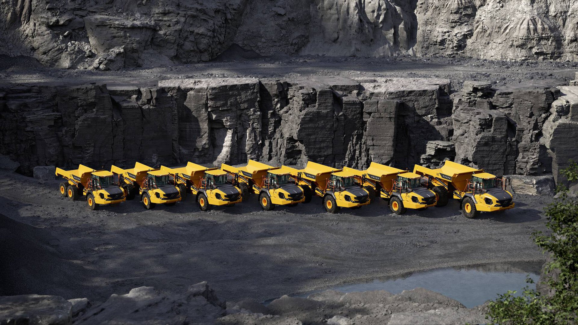 Une flotte premium de tombereaux articulés Volvo en action dans une carrière, illustrant leur gigantesque capacité de terrassement et leur robustesse à toute épreuve
