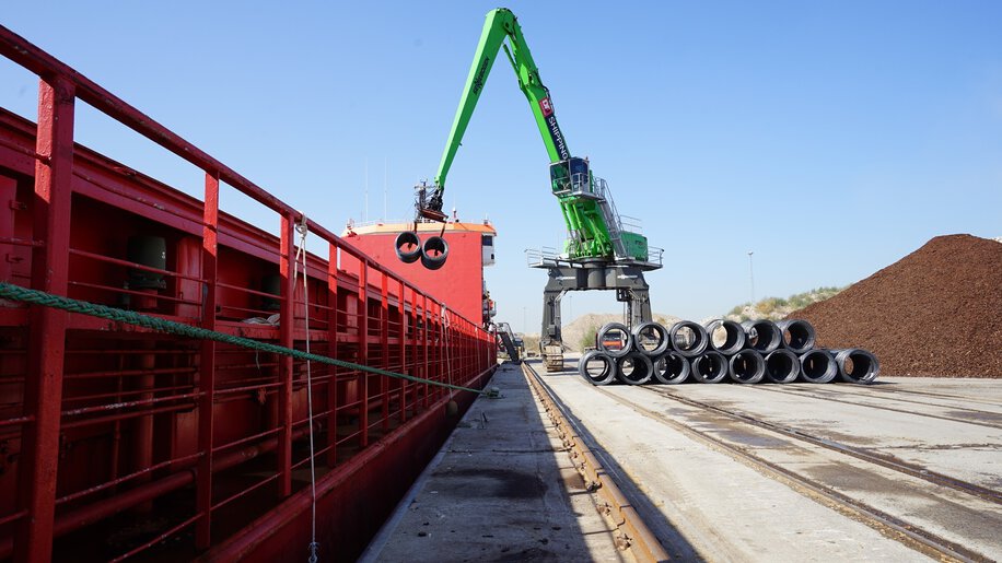 High-reach Sennebogen port handler ensuring reliable material flow and stability during maritime bulk handling and vessel loading operations.