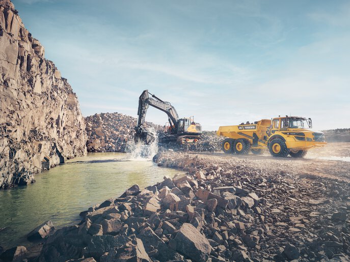 Une grande pelle hydraulique Volvo chargeant un tombereau dans une carrière, offrant une productivité et une polyvalence supérieures dans des environnements exigeants