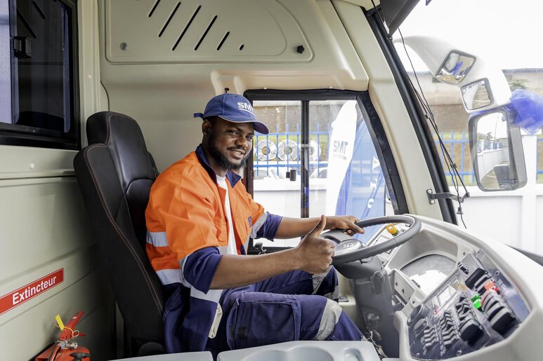 Un conducteur professionnel au volant d’un bus moderne, illustrant la vision de SMT pour une mobilité des personnes sûre, fiable et performante.