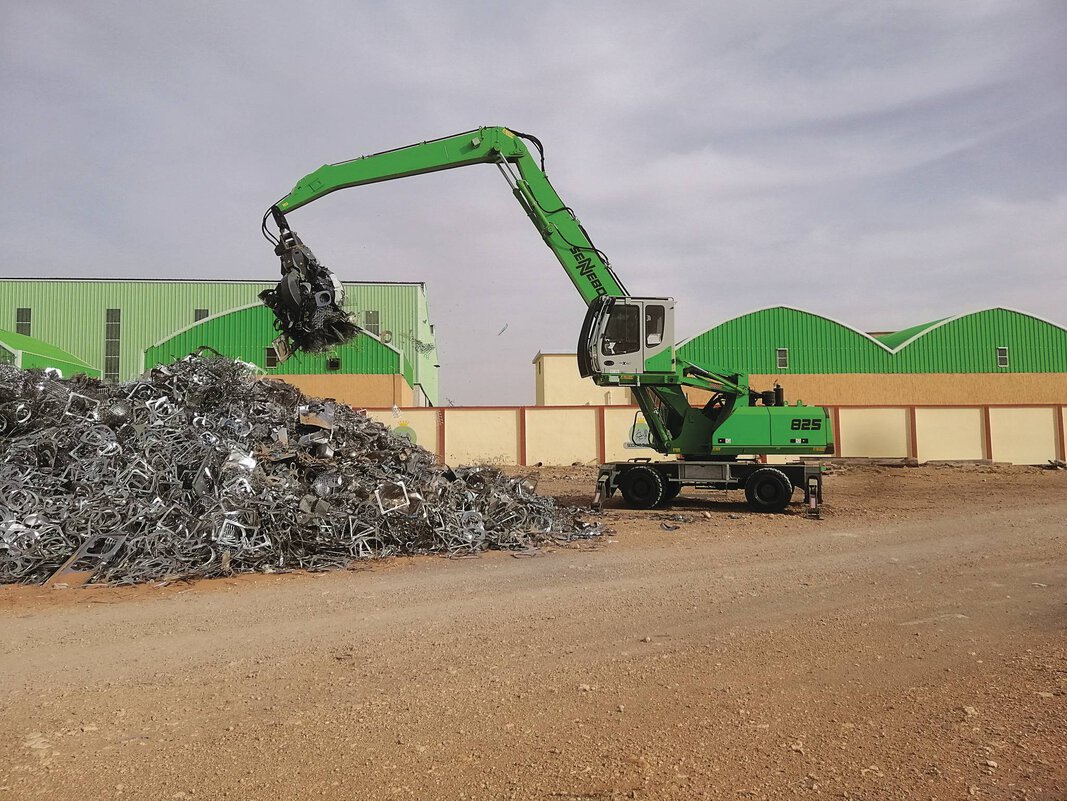 Sennebogen Green Line material handler sorting scrap metal in a high-throughput recycling center, showcasing precision and industrial reach