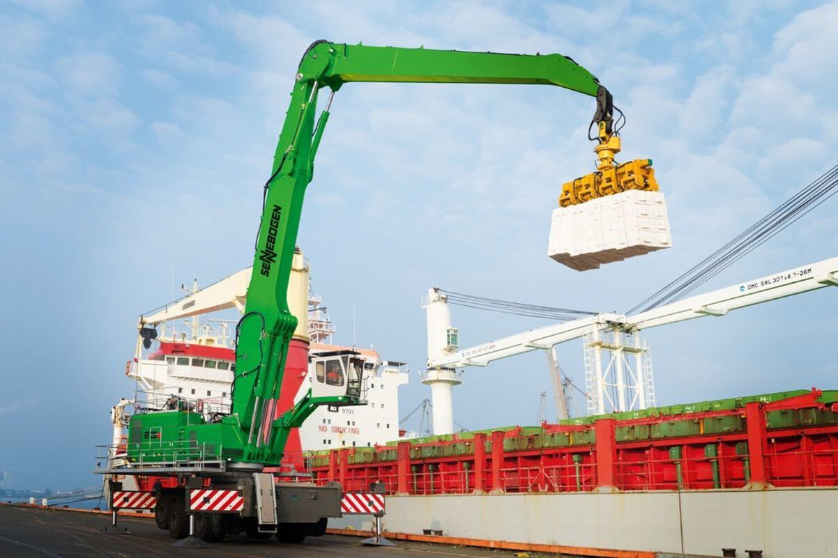 High-reach Sennebogen port handler discharging a vessel at a maritime terminal, optimized for strategic port logistics and bulk handling